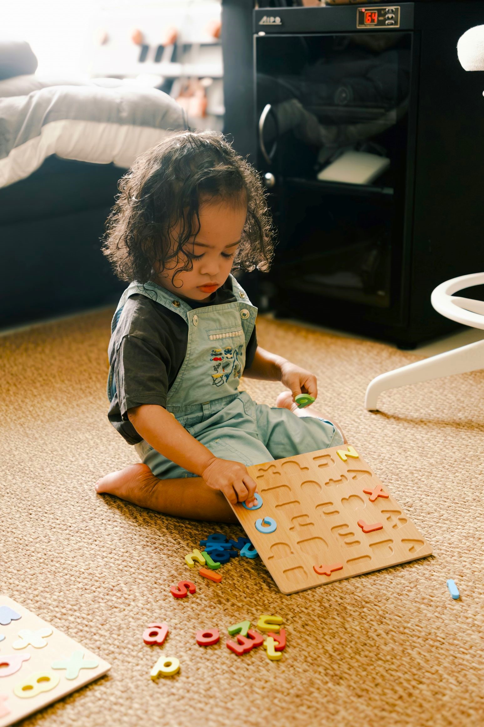 Young child engaging independently with a learning puzzle at home, developing focus, routine, and responsibility by Increasing Homework Independence.