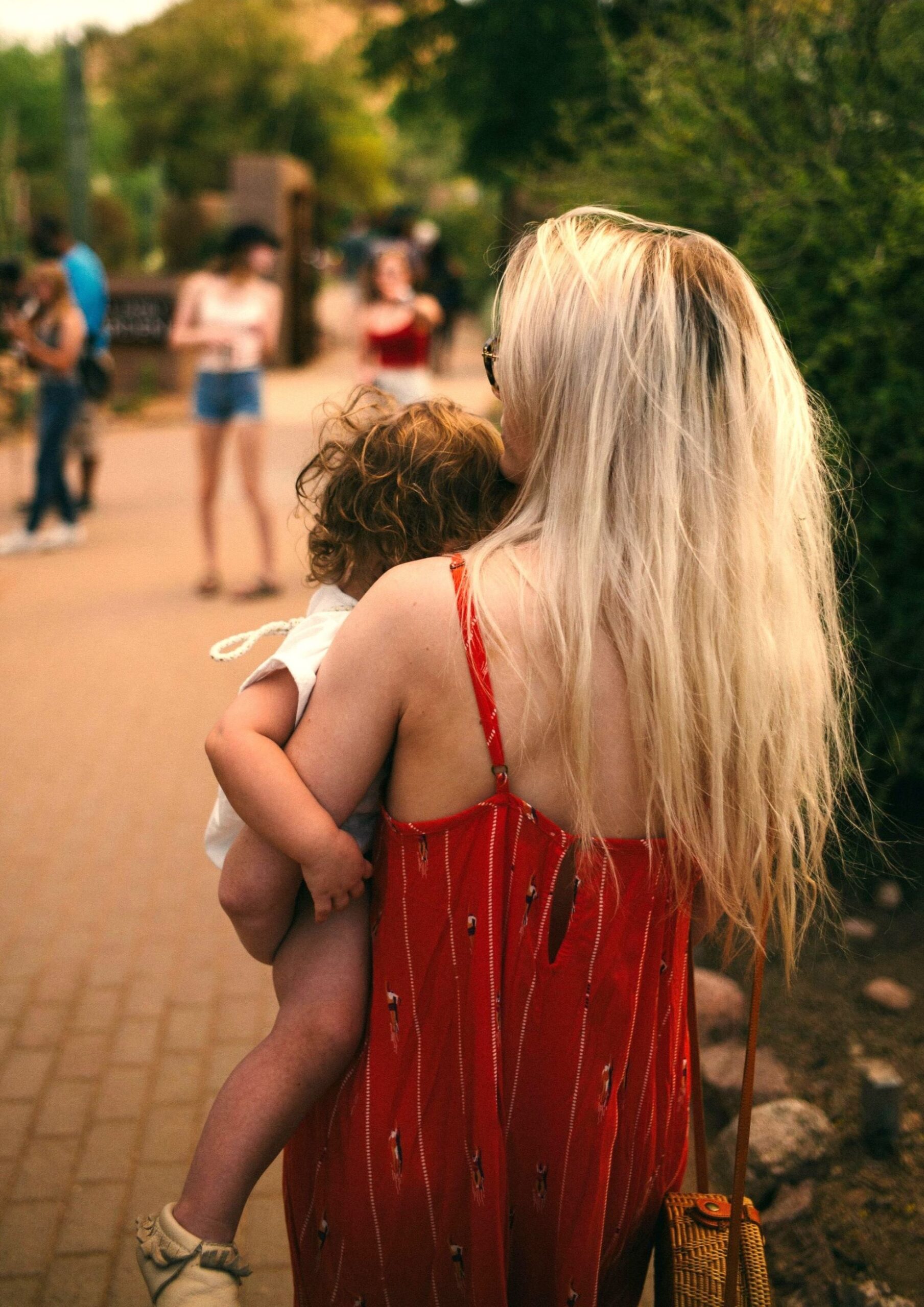 Mother holding baby outdoors, reflecting identity shifts and emotional changes associated with postnatal Womanhood Worries.