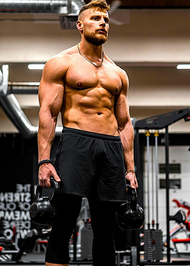 Kettlebell training by a muscular man in a gym, highlighting the importance of physical activity for mental health and stress relief.