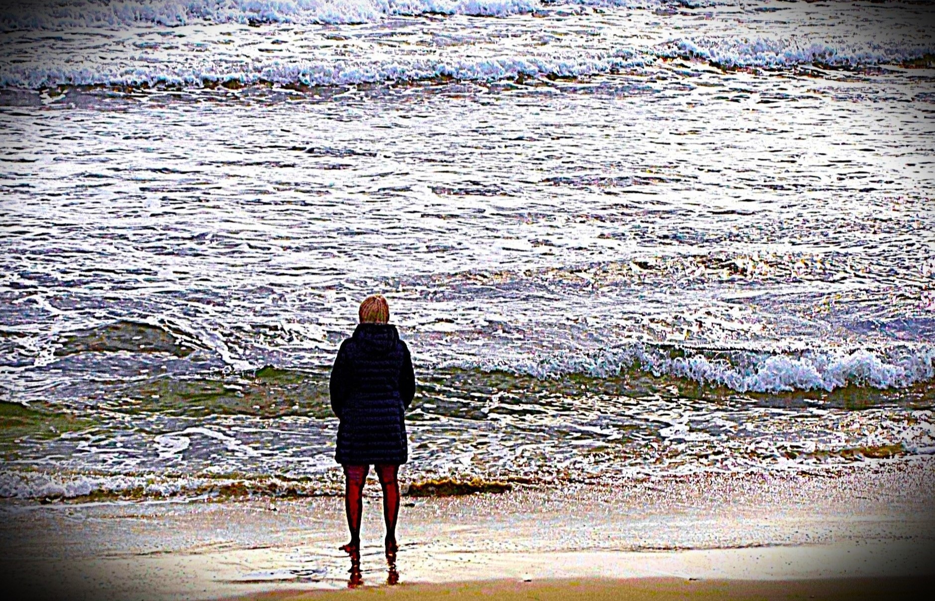 A person standing alone on the beach, gazing at the ocean, symbolising solitude, contemplation, or emotional introspection. The scene evokes feelings of calmness, reflection, and mental well-being.