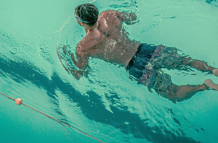 Man swimming in pool, showing strength, balance, and growth, symbolising Male Emotional Confidence through exercise practice.