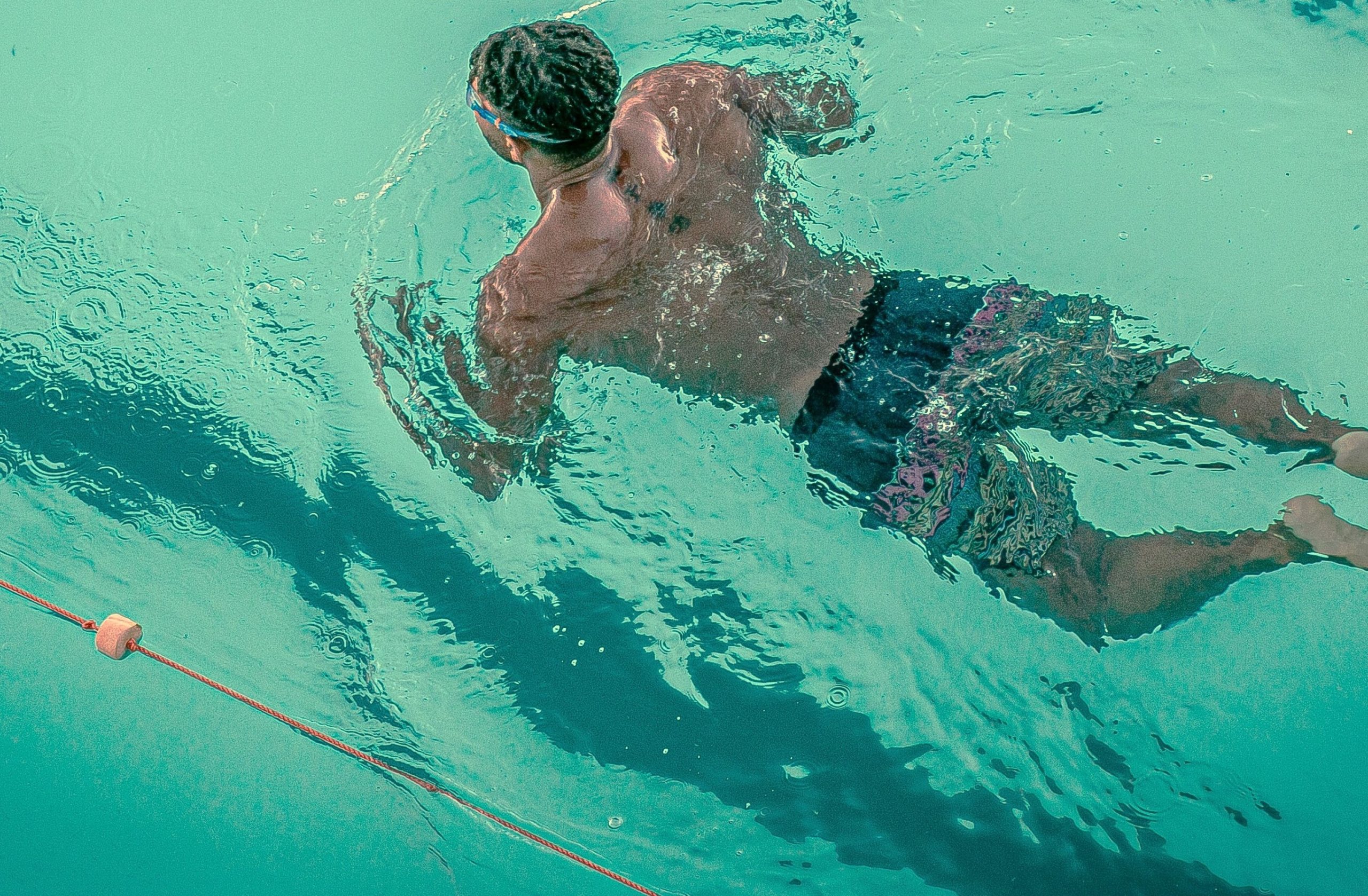 Man swimming in pool, showing strength, balance, and growth, symbolising Male Emotional Confidence through exercise practice.