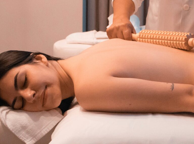 Relaxed woman receiving a back massage in a spa setting, suggesting relaxation and stress relief.