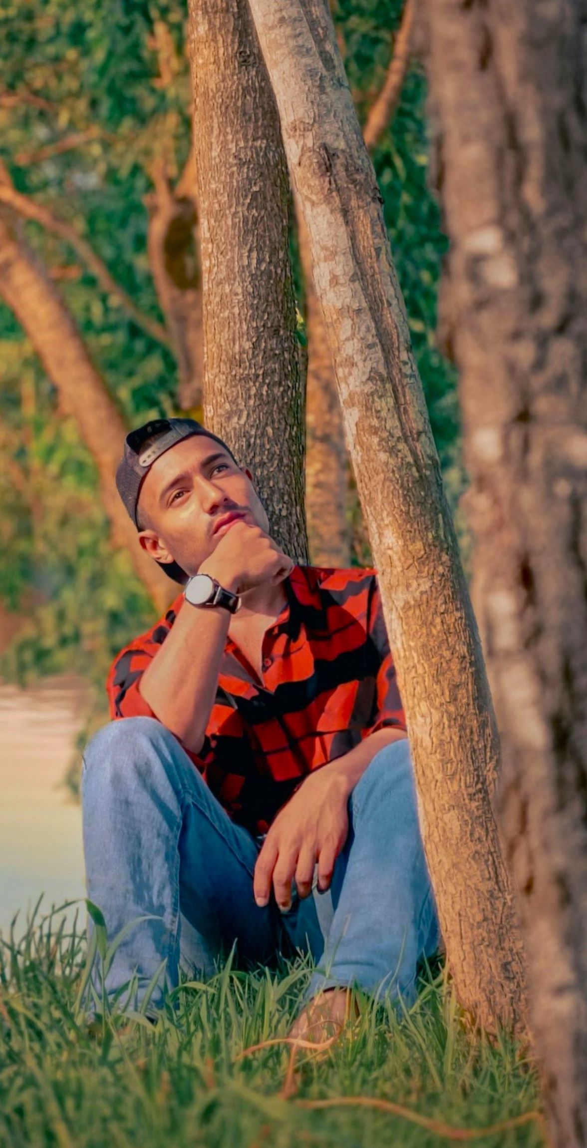 A young man sitting alone in nature, looking back at life lessons during times of feeling no sense of purpose left during the Psychological Search For Meaning.