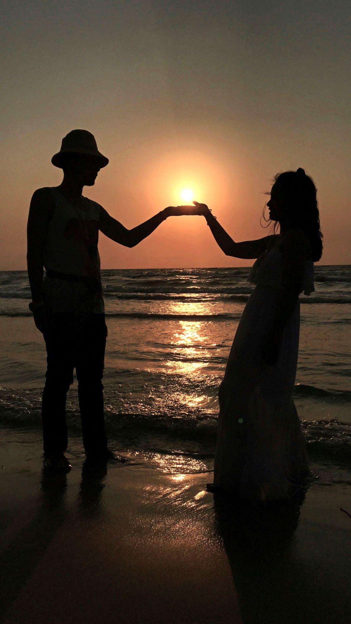 Couple holding hands at sunset reflecting modern attachment styles and Attachment Behaviors In Couples.