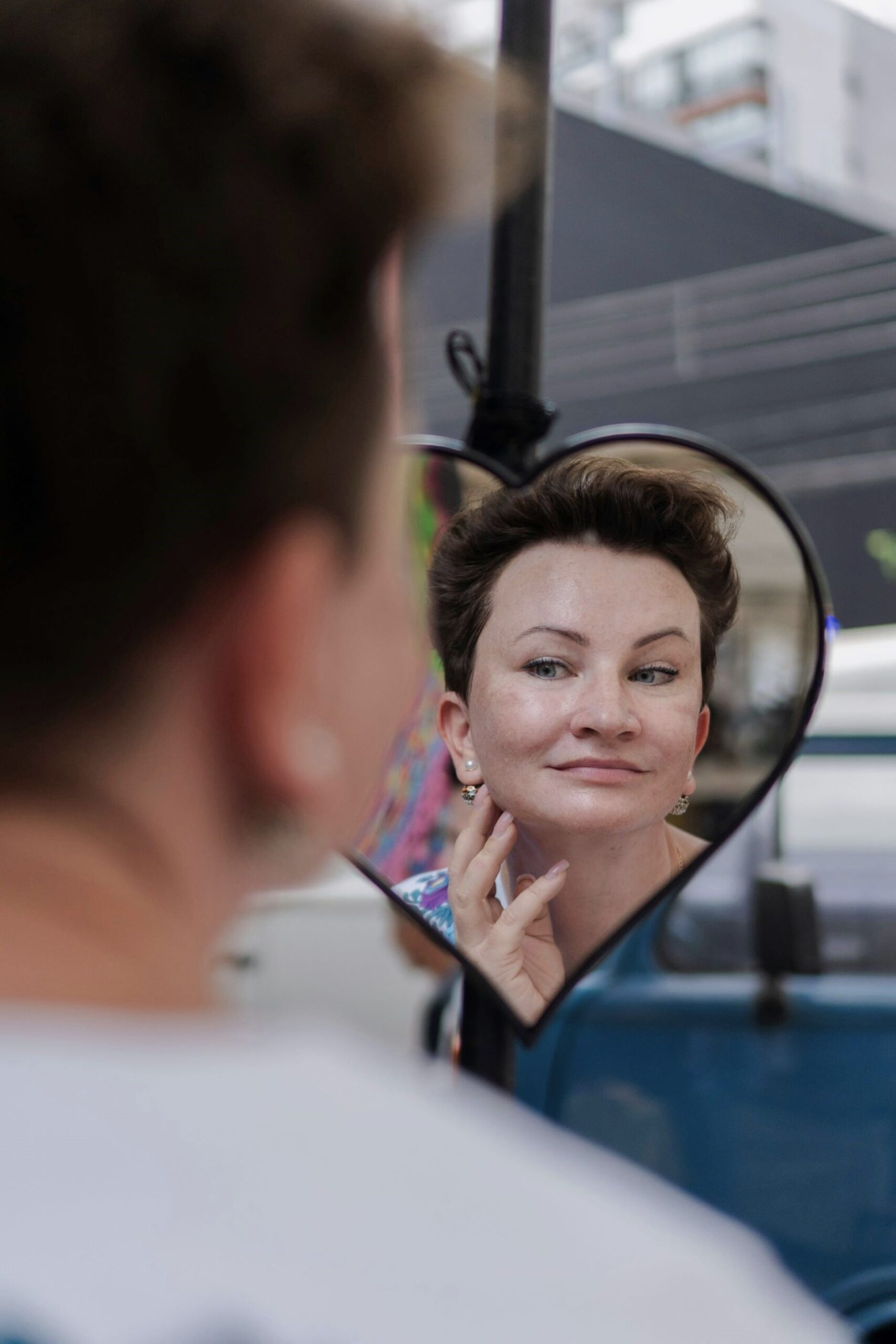 A woman reflecting in a mirror, building self-awareness and improving physical state through Gestalt therapy and Quality Awareness Practice.