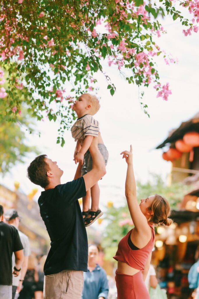 Parents lifting child while prioritizing healthy quality time over social norms in Understanding Evolving Families.