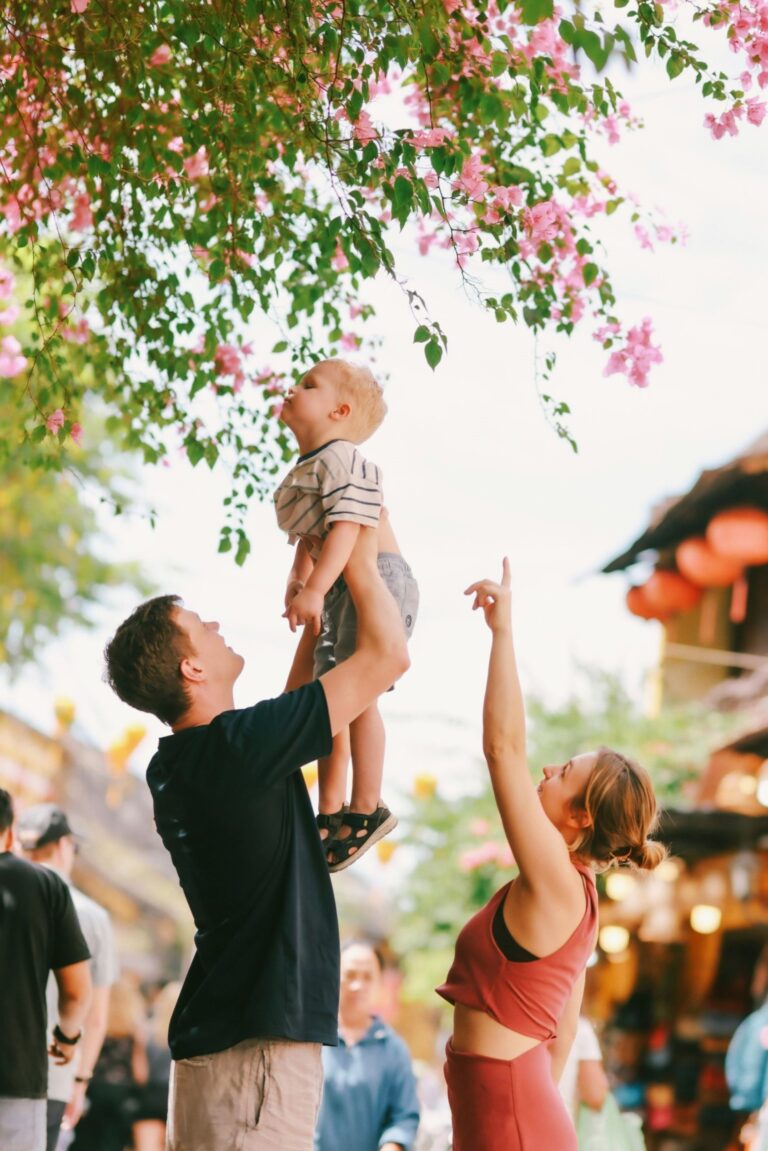 Parents lifting child while prioritizing healthy quality time over social norms in Understanding Evolving Families.