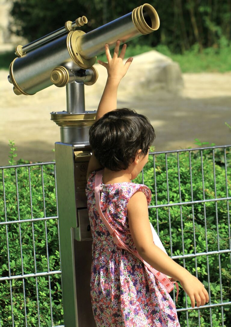 Young girl independently reaching for a telescope representing curiosity, guidance and trust where Parenting Practices Promote Protection.