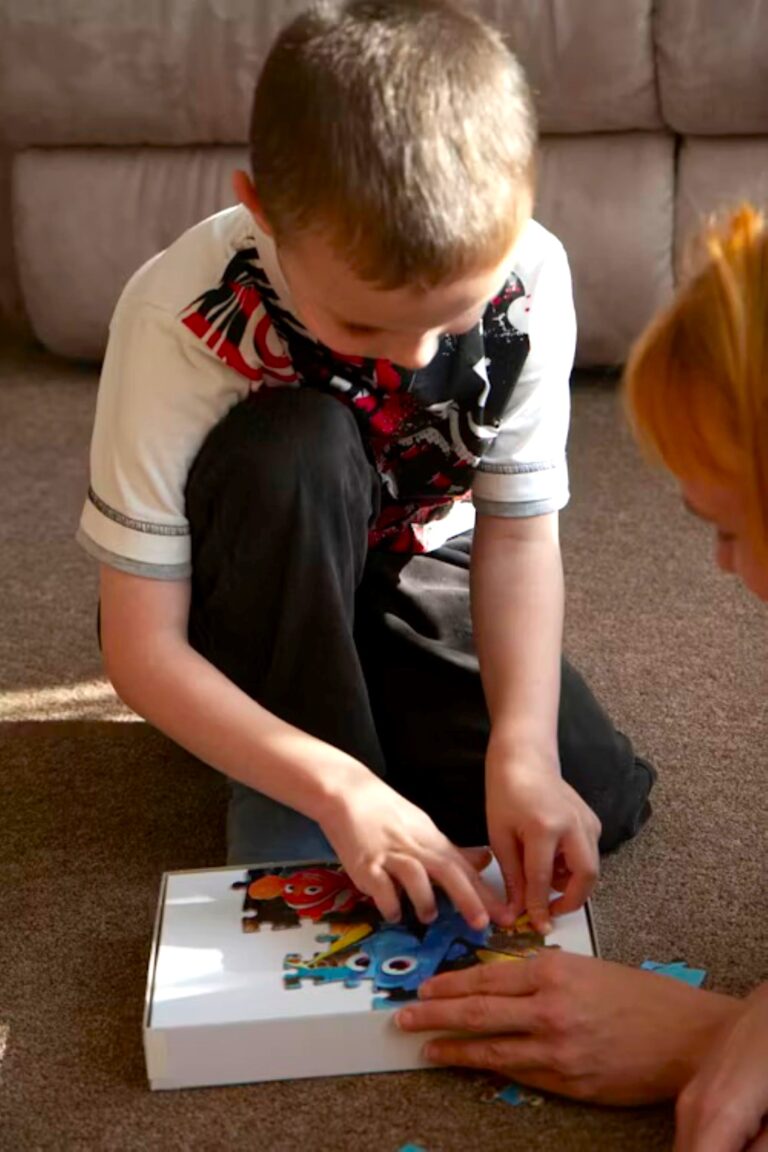 Child completing puzzle with adult guidance, supporting growth socially and mentally through Social Development.