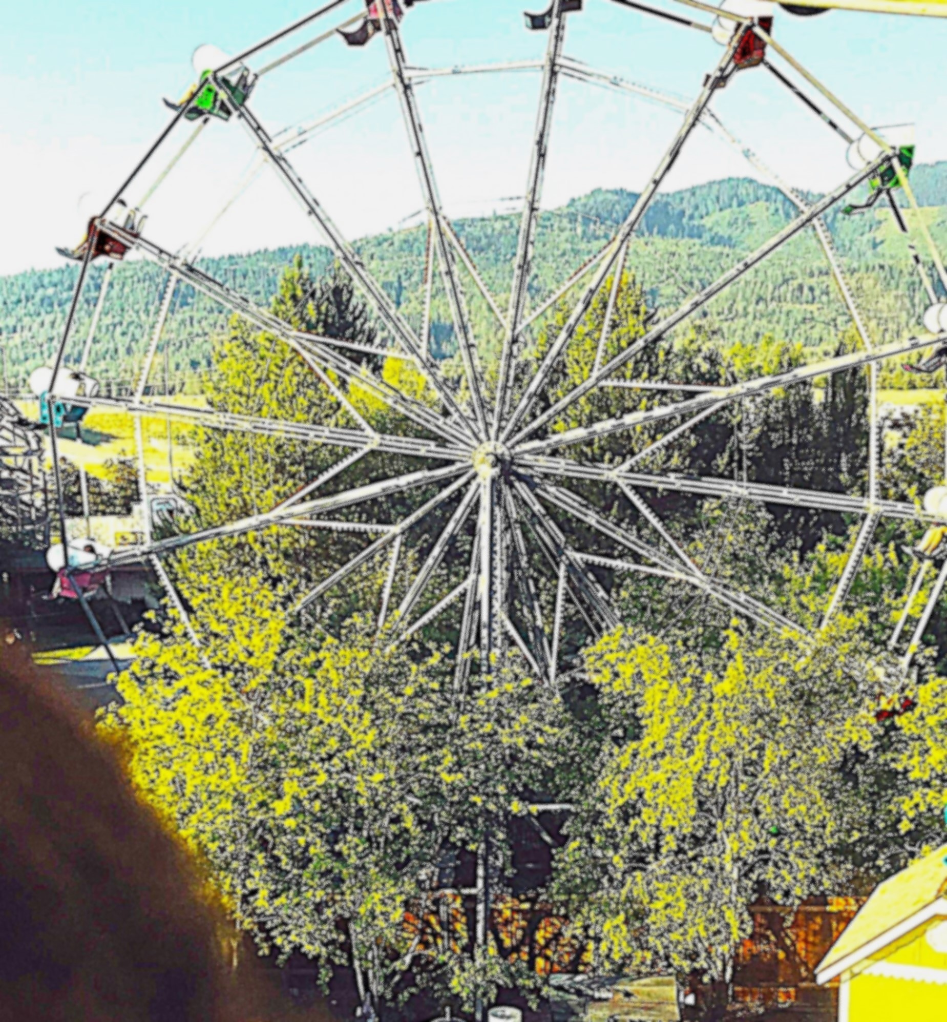A colourful image of a Ferris wheel at an amusement park amid greenery and trees, with a mountainous landscape in the background, evoking feelings of nostalgia and childhood joy.
