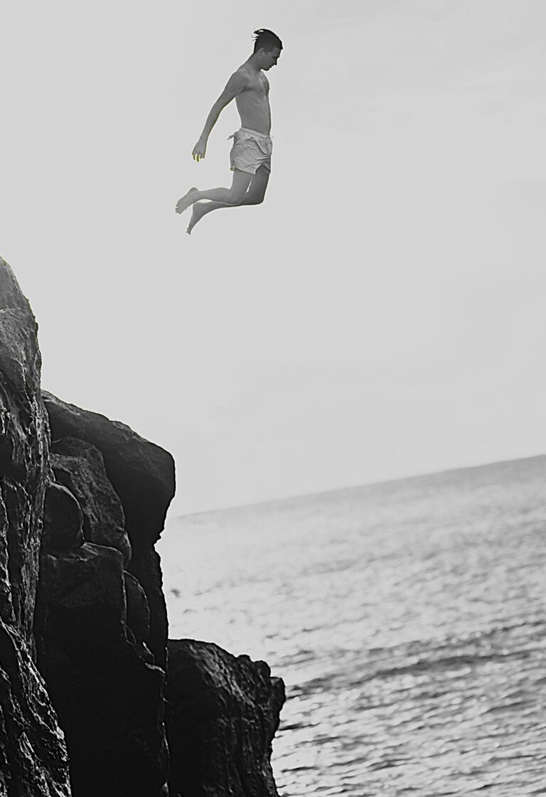 A person jumps from cliffs into the sea, symbolising courage, freedom, and Techniques To Stop FOMO in daily life.