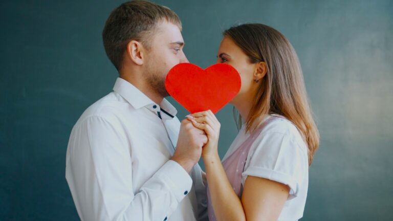 Couple holding heart between faces to symbolise emotional distance and unresolved tension from Lack Of Intimacy.