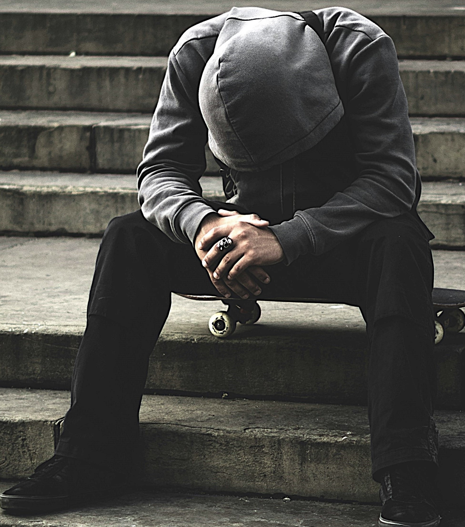 Person sitting alone with head down, showing Zones Of Withdrawal linked to loneliness, trust issues, and emotional pain.
