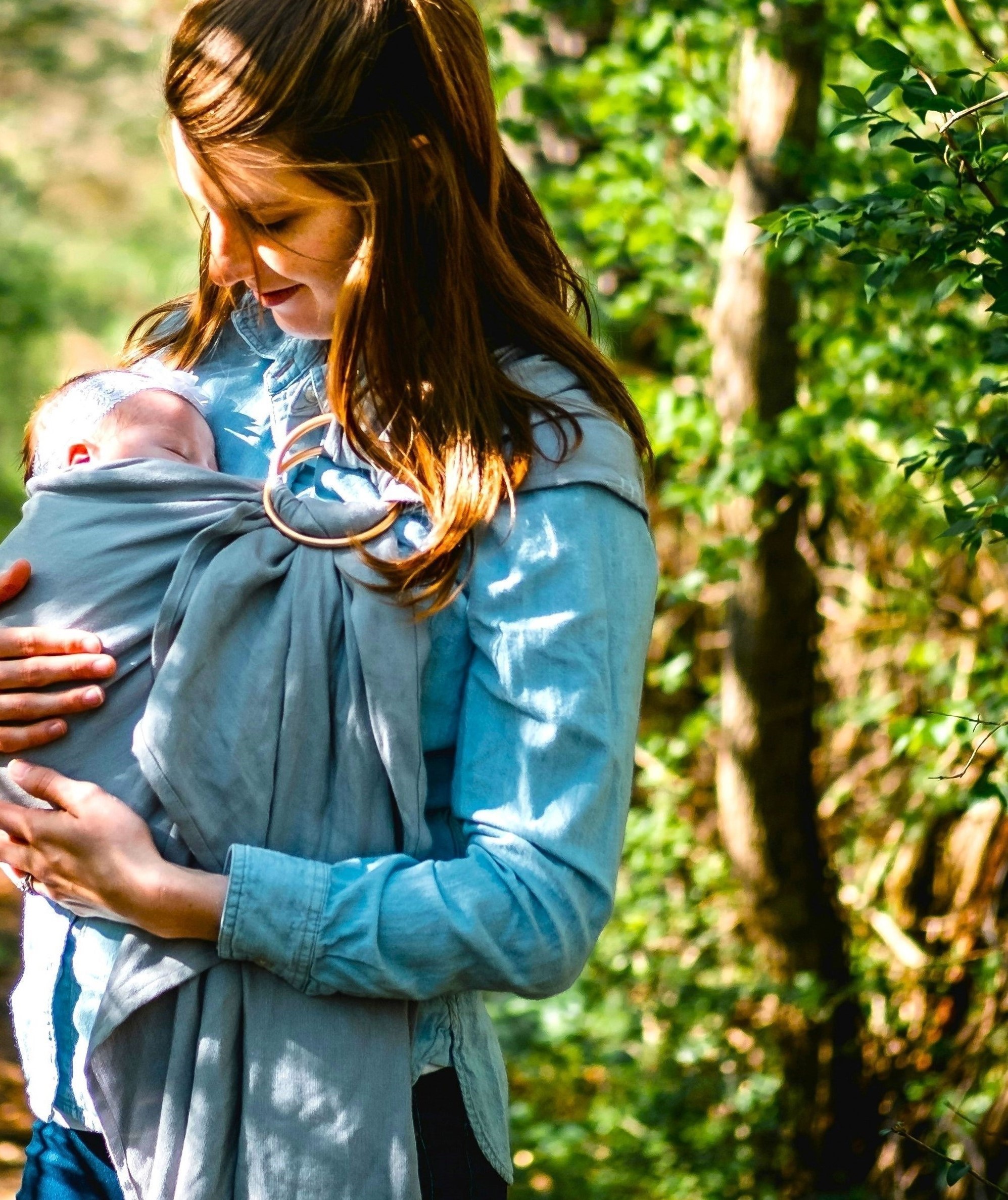 Gentle mother holding her sleeping baby in a forest, symbolising maternal bonding and emotional security.