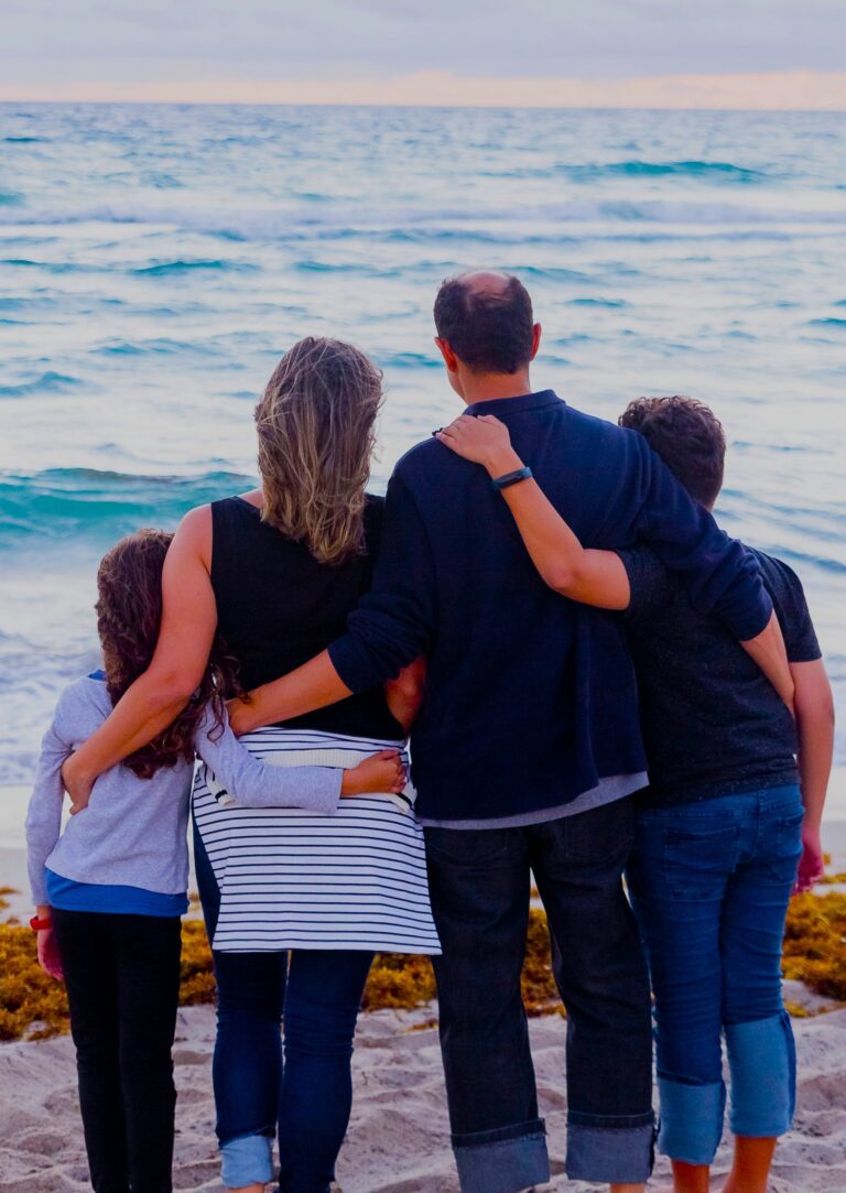 A family stands together by the sea, reflecting a Family Bonds Narrative and its impact on shared relationships.