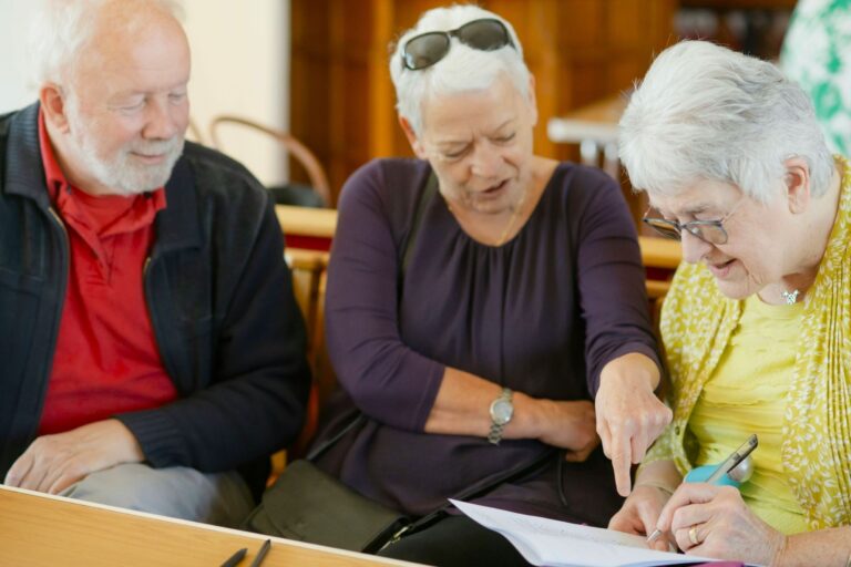 Older adults reviewing information together, showing dementia awareness and support in mental and physical health Working With Dementia.