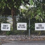 Recovery messages on a fence offering hope, supporting suicide prevention and stigma awareness.