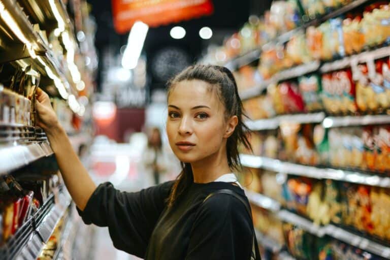 Person in shop tempted by sale items, reflecting urge to buy and psychology behind Mindful Spending Behavior.
