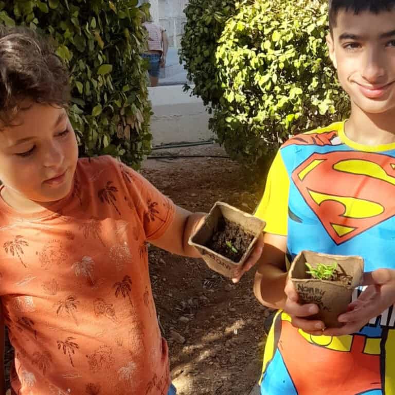 Growing children holding small plant pots with soil, symbolising nurturing and mental well-being.