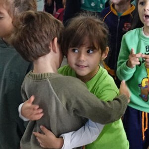 Child comforting a distressed peer, promoting emotional support and empathy in social settings.
