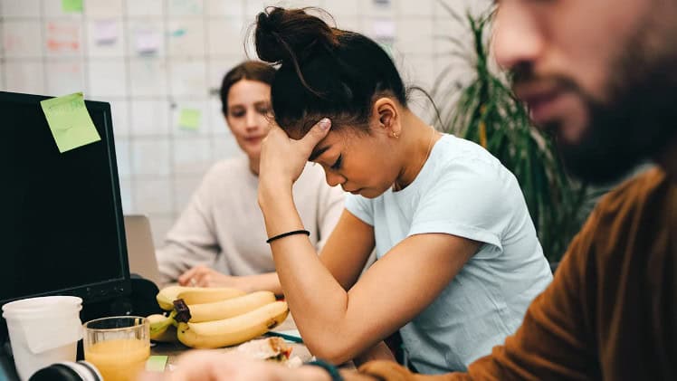 Feelings of stress and overwhelm in a young woman during a group therapy session, highlighting mental health challenges and the importance of emotional support and counselling.