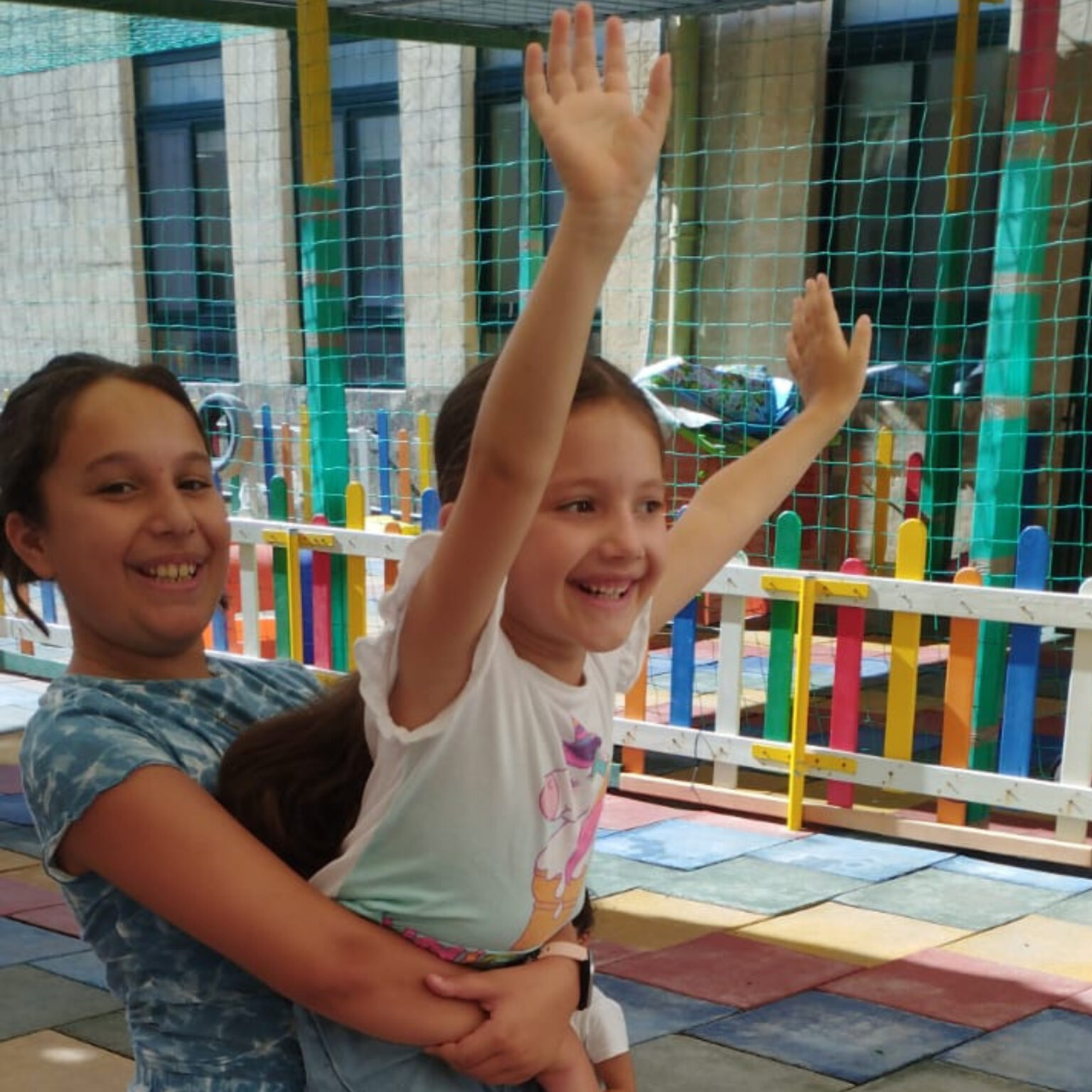 Cheerful children playing together at an outdoor playground, joyful and happy, promoting mental wellbeing and social interaction among kids, with colourful play equipment and a sunny atmosphere.