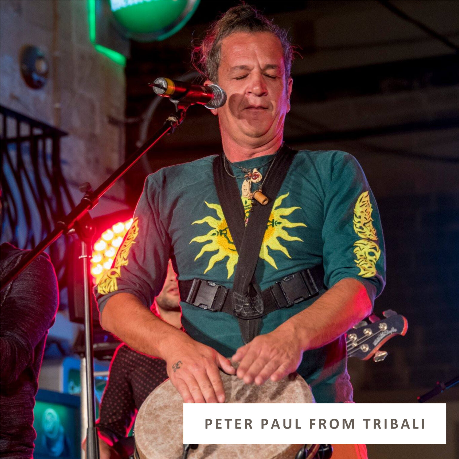 Overwhelmed musician with closed eyes and furrowed brow performing on stage, conveying emotional exhaustion and vulnerability in a live music setting.