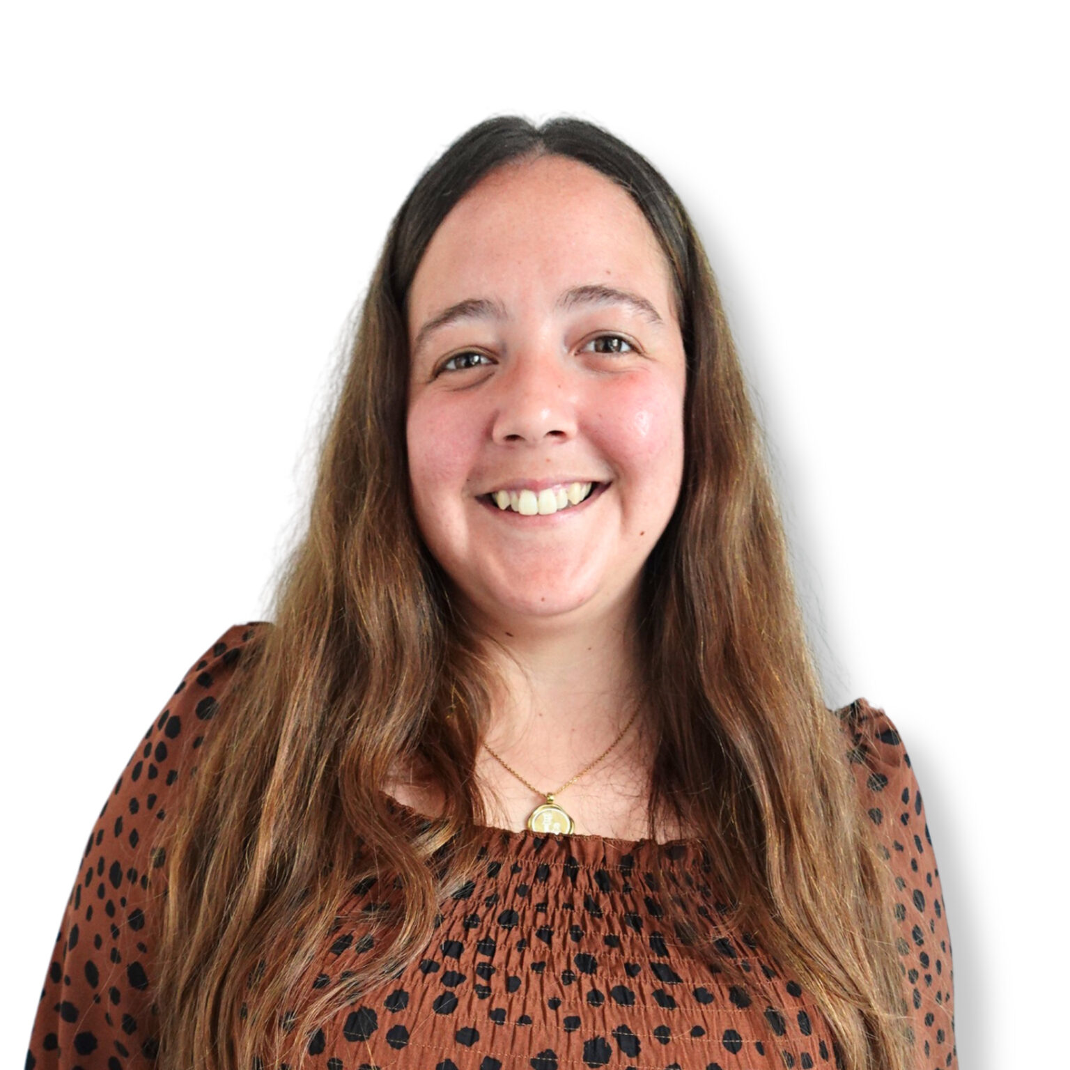 A young woman with long brown hair smiling warmly, wearing a patterned brown top and a gold necklace, against a plain white background.