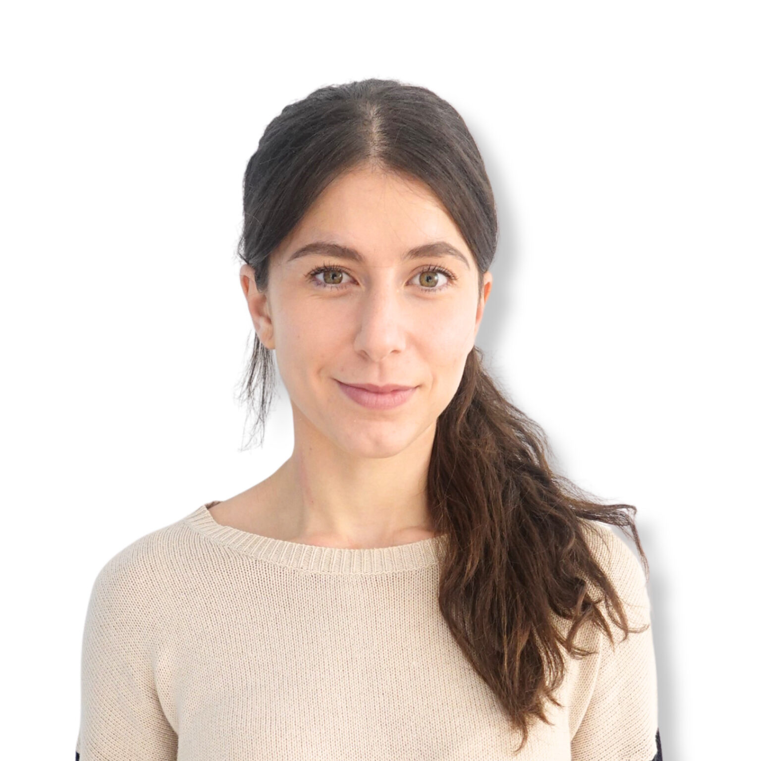 Calm young woman with brown hair and green eyes smiling softly, dressed in a beige sweater, against a plain white background, conveying mental wellness and emotional balance.