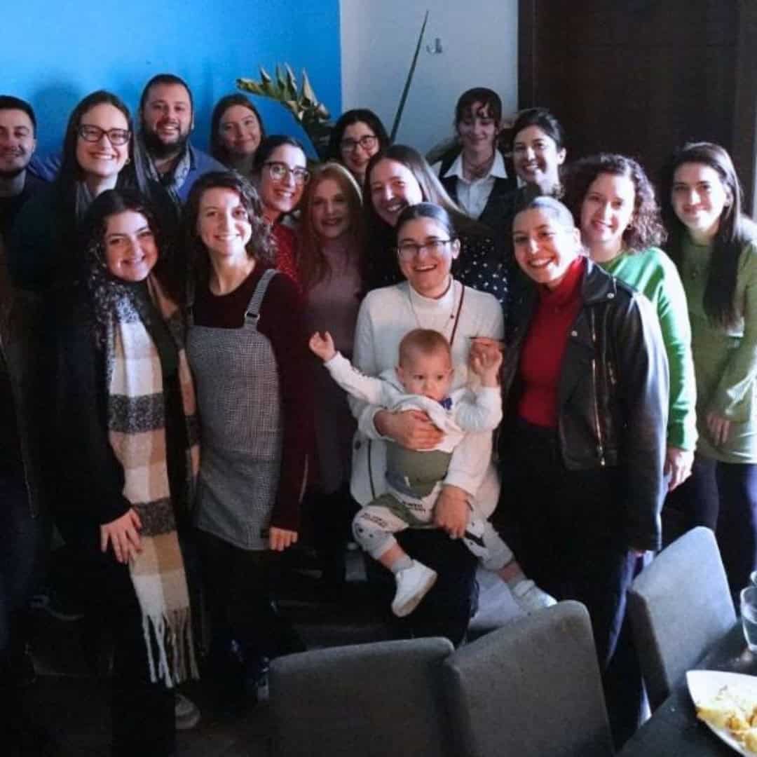 Group of diverse friends and colleagues smiling together during a social gathering, promoting mental health, community support, and positive social connections.