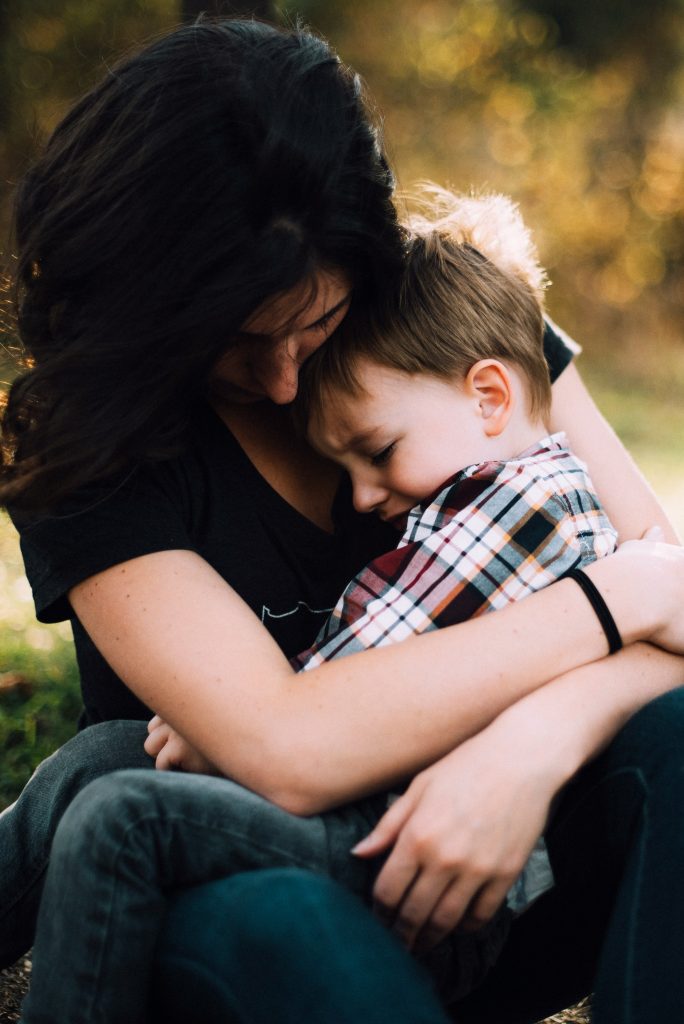 A young boy is shown embracing his mother in a tight hug, embracing the power of unconditional love. Embracing your children for who they are really benefits them.