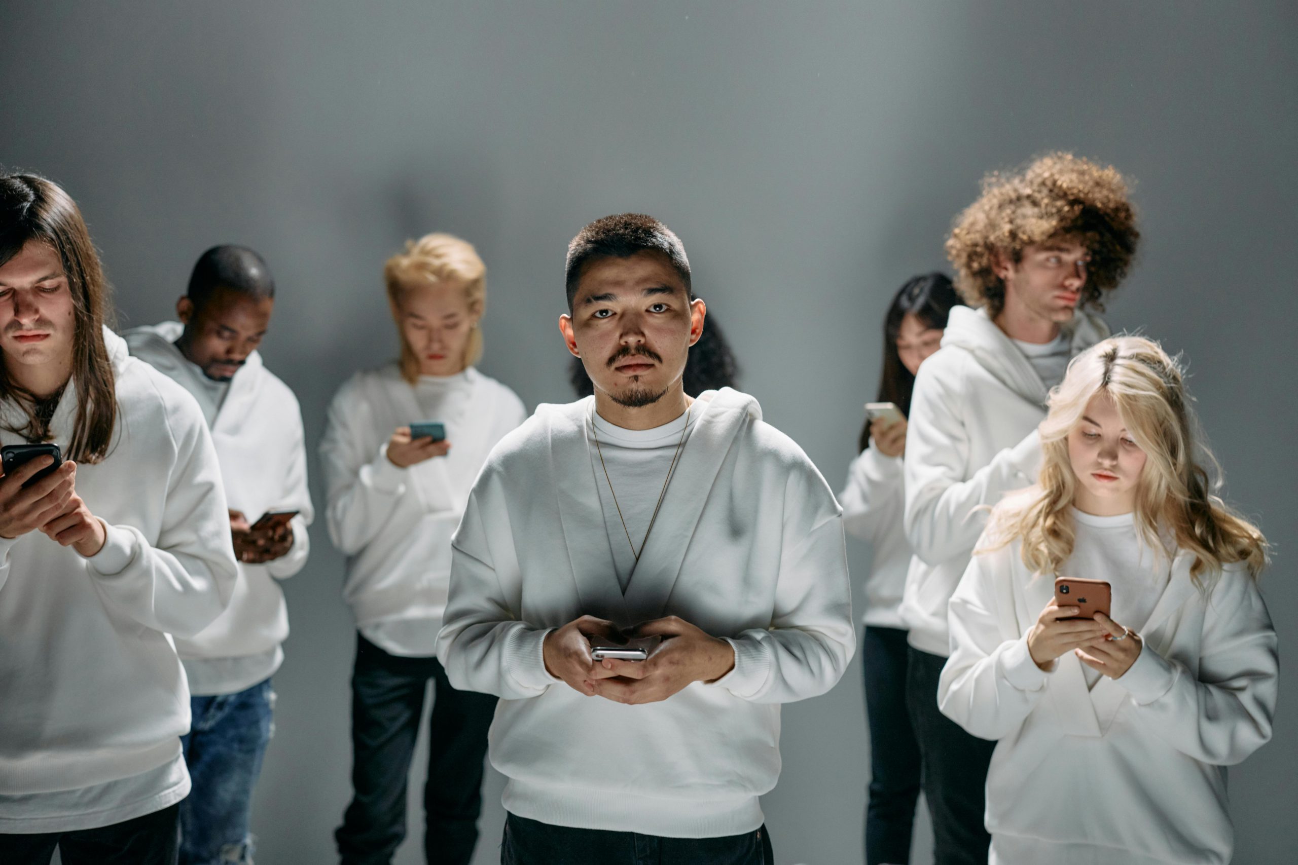 A group of people can be seen all on their phones, which isn't healthy in the long run. Many ways make helping kids reduce their screen time in summer possible.