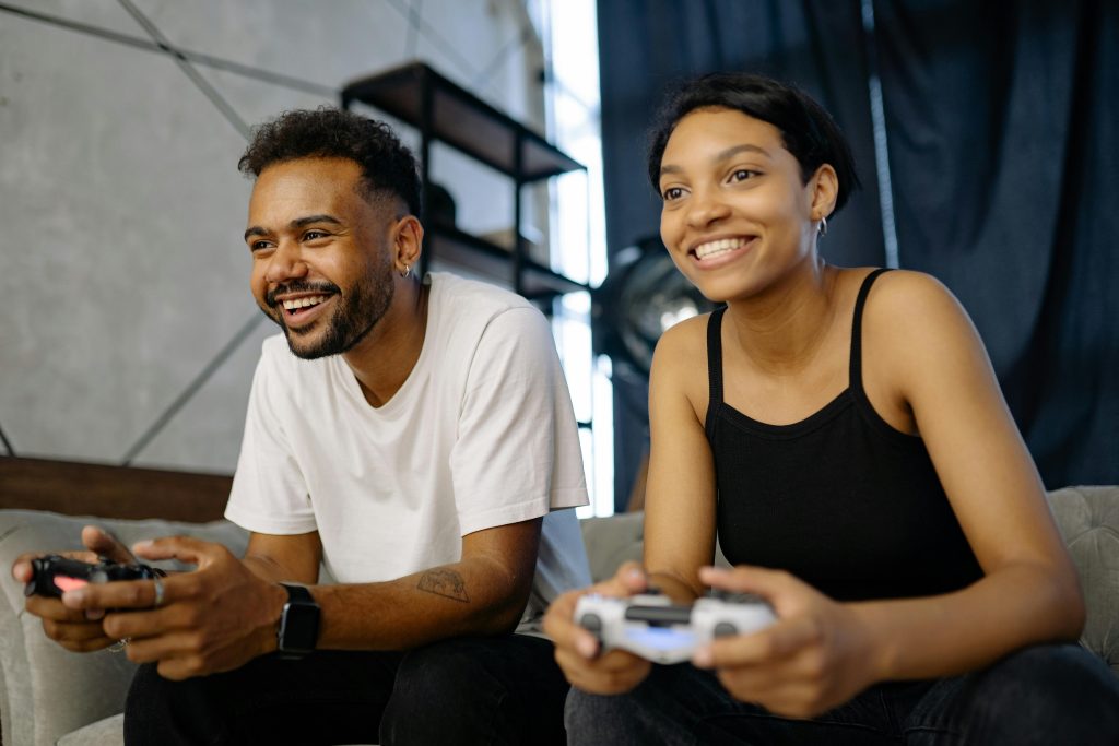 A woman is playing video games with her boyfriend, having a blast together. This is a good example of how shared hobbies can result in significant improvements in both health and relationships.