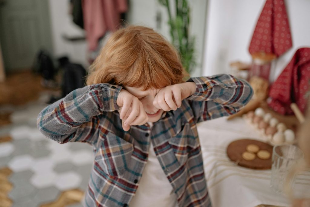 A ginger child is seen crying because they've come to realize that their parents are separating. Separation anxiety, while often described as unbearable, can actually be handled by both kids and their parents.