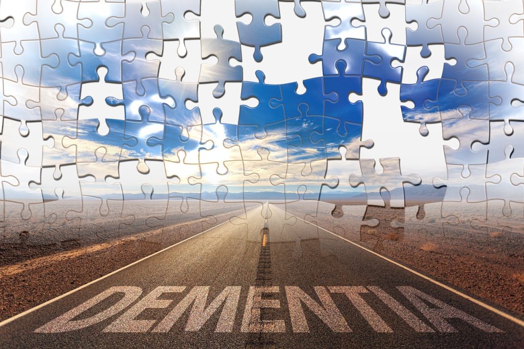 A nearly finished jigsaw puzzle with the word 'DEMENTIA' at the very bottom, the jigsaw puzzle being used as an opportunity to help support people going through dementia.