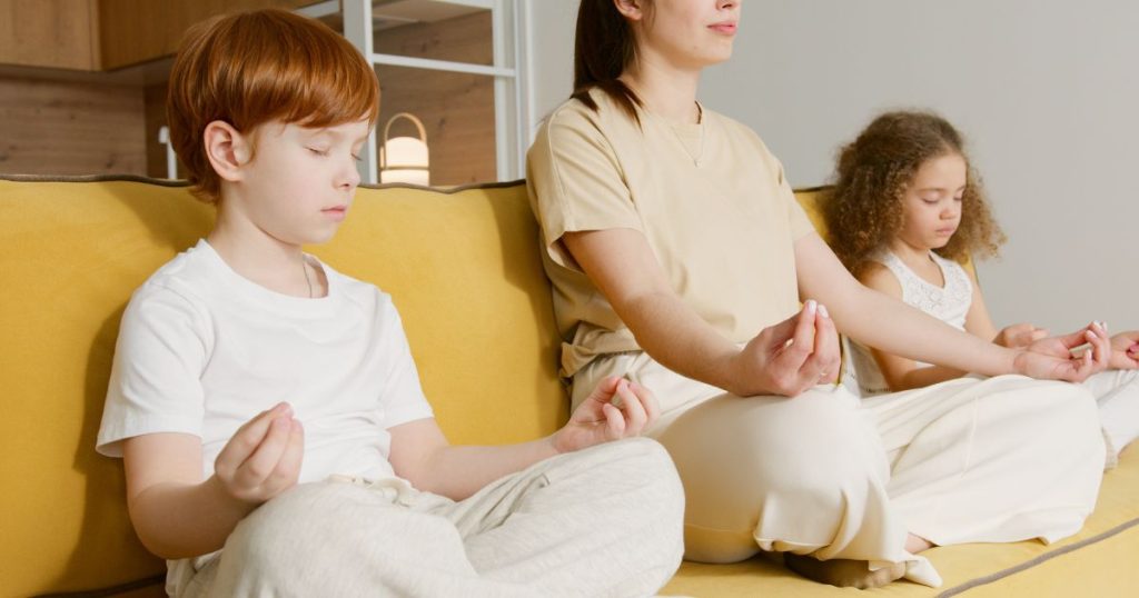 A mother teaching her daughter & son how to breathe in & out via mindfulness, to teach them about the power in breathing with calming kids.