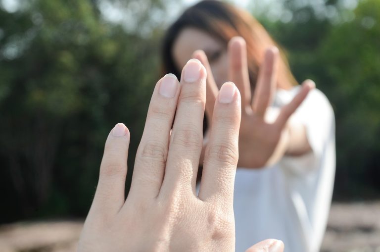Two people reaching out without touching, showing avoidant attachment in relationships and emotional gaps.