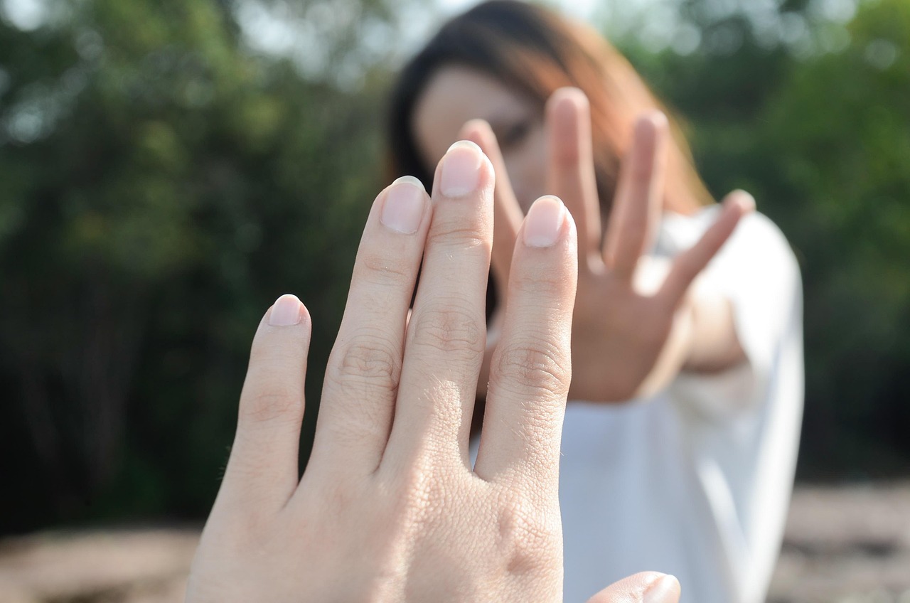 Two people reaching out without touching, showing avoidant attachment in relationships and emotional gaps.