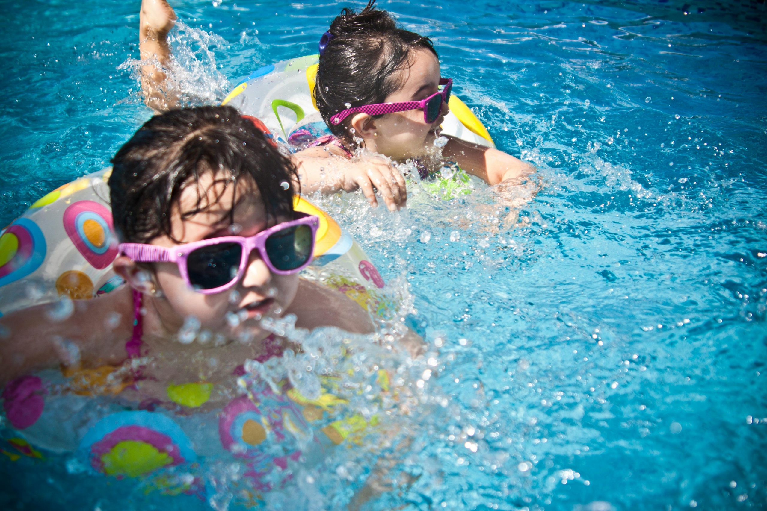 Two children enjoying a pool despite initial water fear.