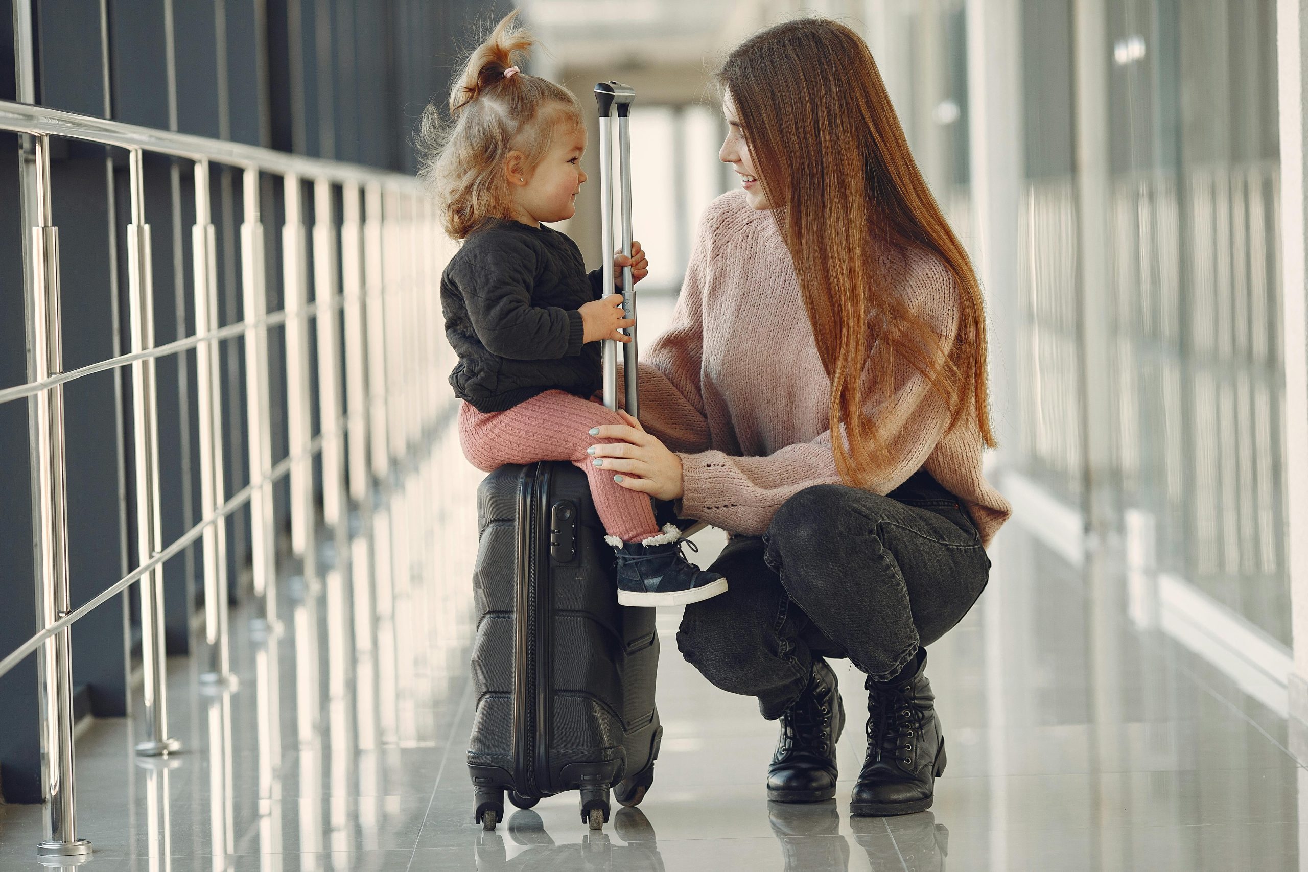 Kid-friendly trips captured in a caring moment between mum and toddler at airport, showing connection and planning.