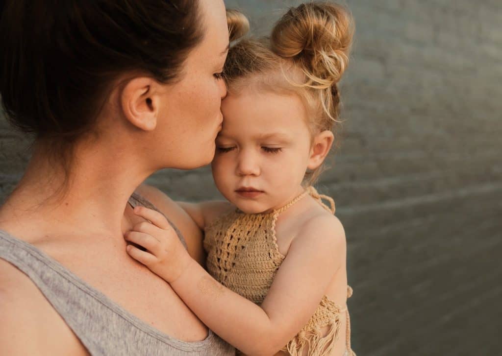 Mother comforting young girl close-up.