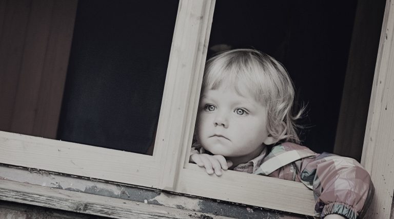 Child gazing out window, symbolising childhood neglect and complex PTSD differences with Mood Changes.