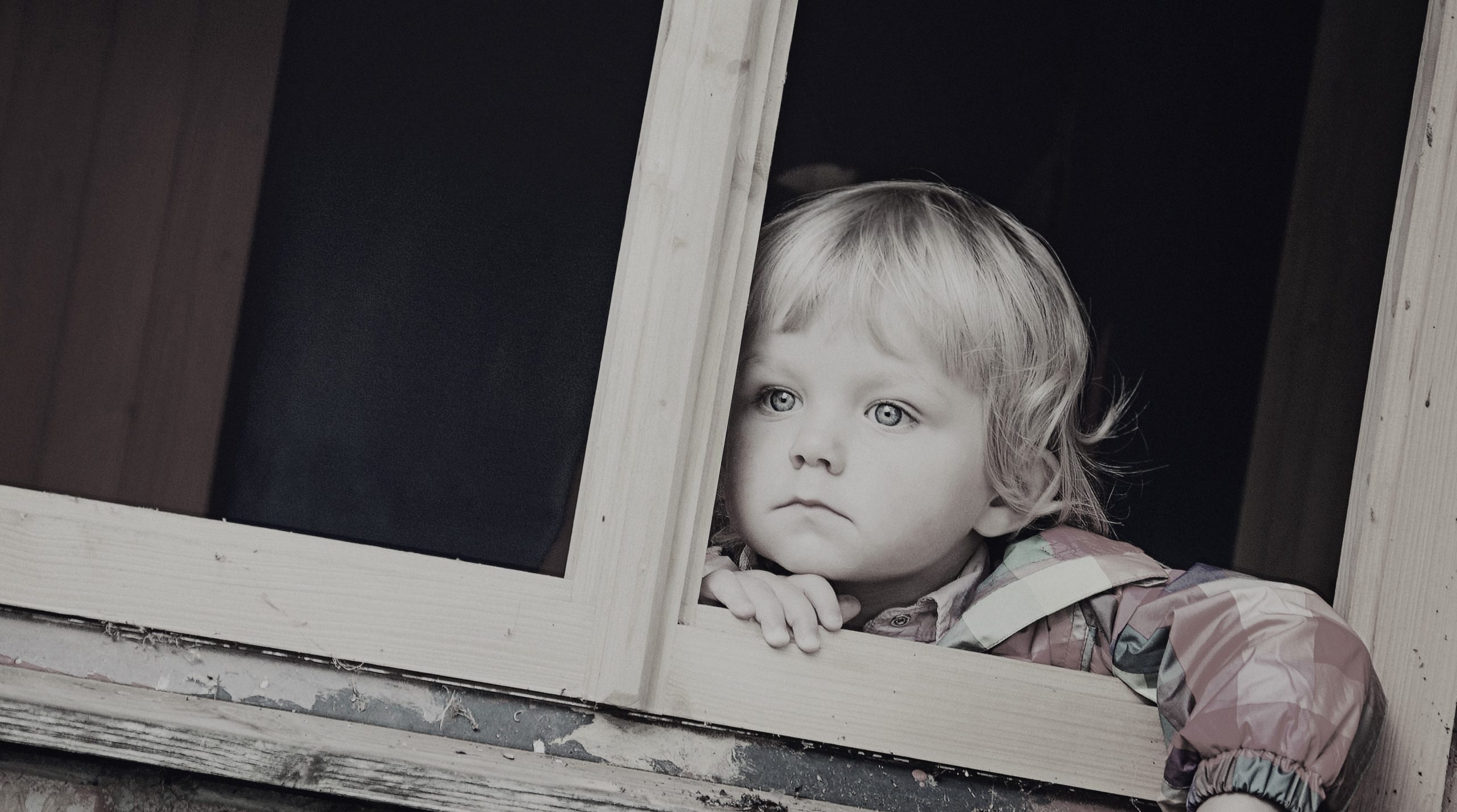 Child gazing out window, symbolising childhood neglect and complex PTSD differences with Mood Changes.