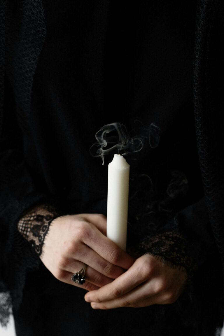 A person holding an extinguished candle symbolising Customised Commemorations after a loved one's demise.
