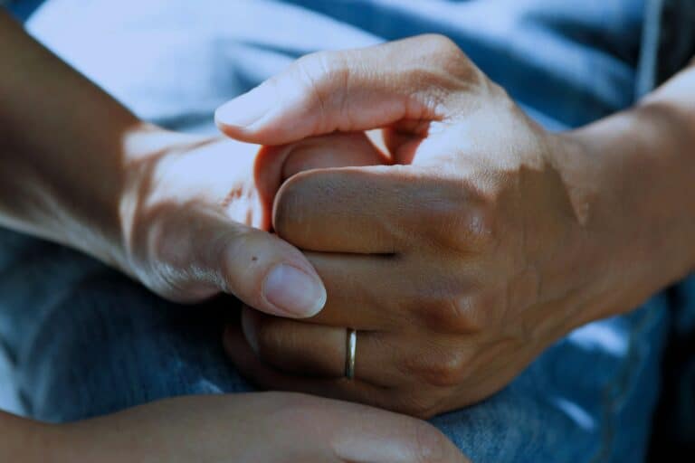 Supportive and empathetic hands holding each other, symbolising emotional support and connection essential for mental health and well-being.