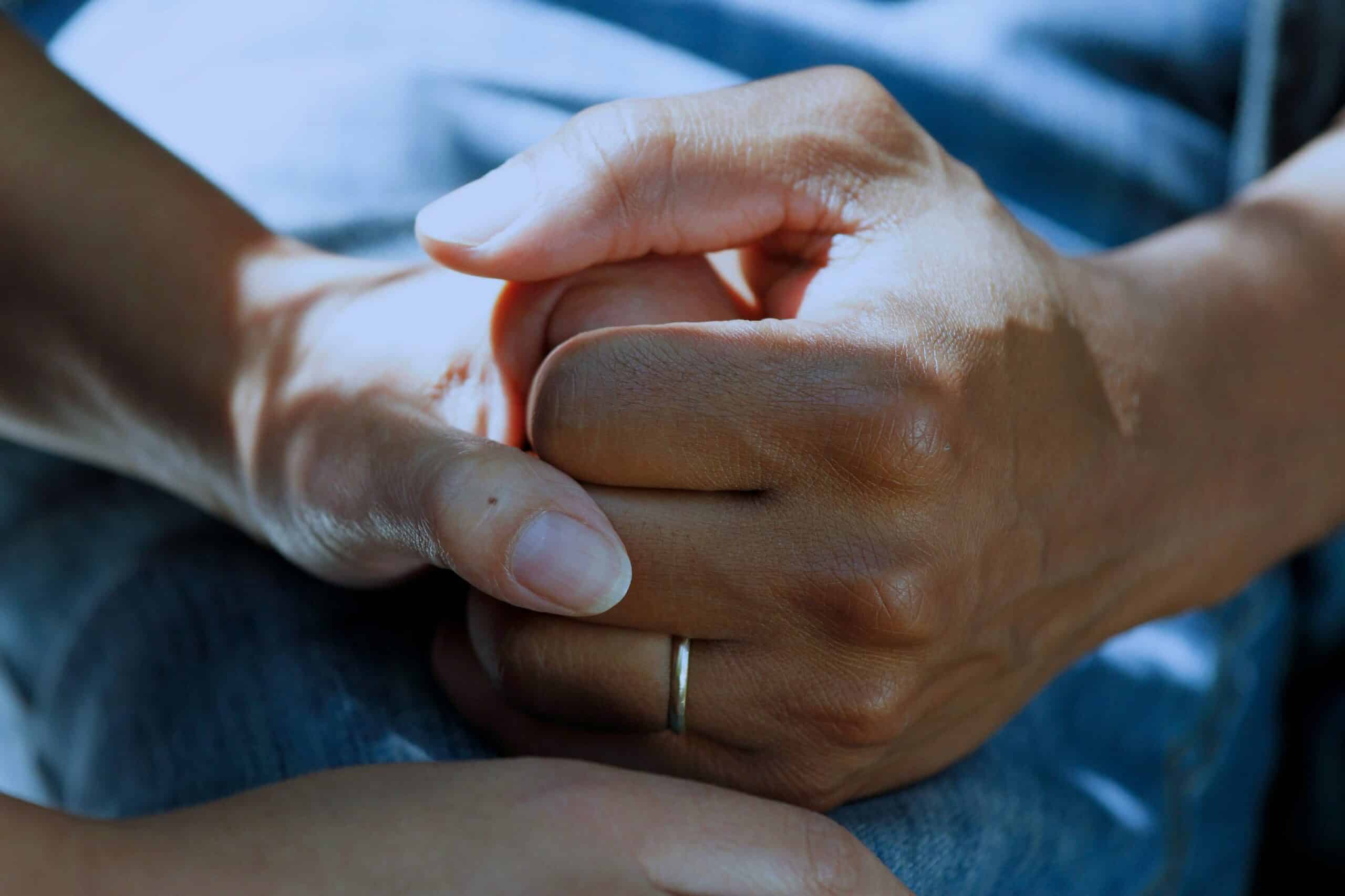 Supportive and empathetic hands holding each other, symbolising emotional support and connection essential for mental health and well-being.