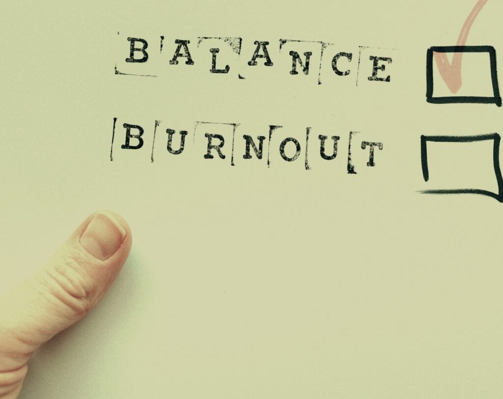 Balance and burnout mental health concept with hand-drawn checkboxes and motivational words on paper.
