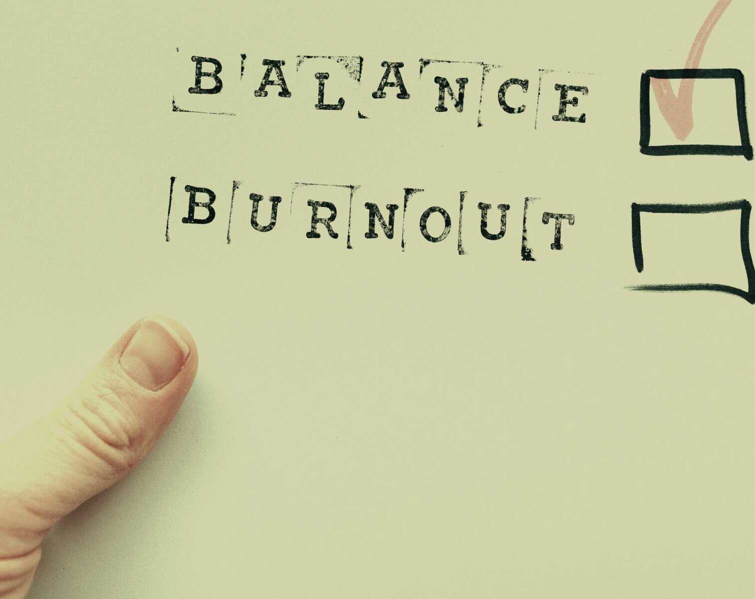 Balance and burnout mental health concept with hand-drawn checkboxes and motivational words on paper.