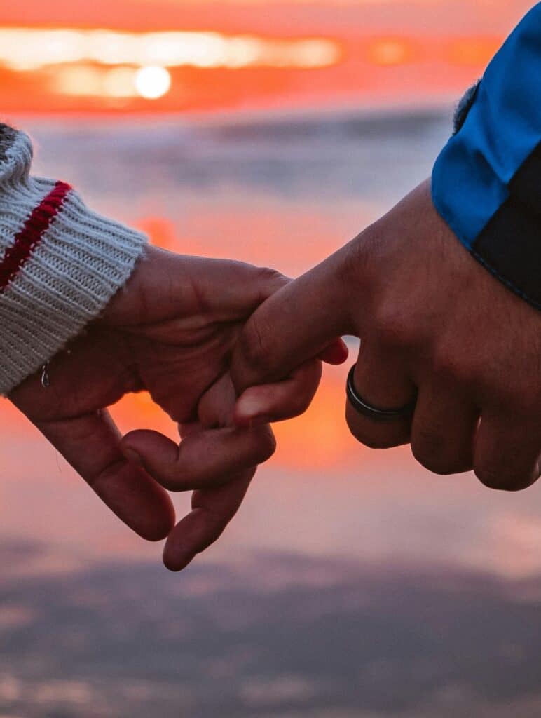 Two people gently linking hands, symbolising how consistent habits can Improve Your Relationship Communication over time.